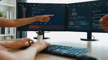 Slow motion back end software developer engineer for computer programming working together on debugging writing computing code, solving complex algorithms display on monitor in office. Burgeoning