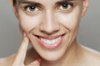 © Nikola Spasenoski - Close-up portrait of a young woman with a captivating smile on gray background