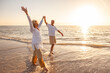 © Darren Baker - Happy Senior Old Retired Couple Walking Holding Hands on Beach at Sunset