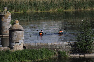 two kayakers on the river next to the water towers of the fort in the lower town of Gdansk