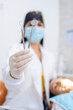 © Carlostock - Dentist shows work instruments, including a dental explorer and a dental mirror, which are in focus. Vertical photo in a private dental office with ample space for text