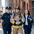 © yisby - a police officer, a firefighter, and a female paramedic. They look happy and relaxed because they have completed their work, public safety agents