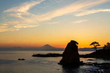 横須賀市秋谷立石海岸から海に沈む夕日と夕焼けに染まる富士山