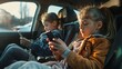 © Sarbinaz Mustafina - Two young girls are sitting in a car, each holding a cell phone. They are both looking at their phones, possibly texting or browsing the internet. Concept of boredom or restlessness
