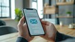 © AIS Studio - Person holding smartphone with email application on screen