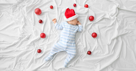 Canvas Print - Cute little baby in Santa hat lying on bed