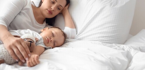 Poster - Adorable baby sleeping with toy and mother on bed