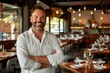 © piai - A happy male owner standing in restaurant