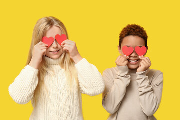 Canvas Print - Cute little children with red paper hearts on yellow background. Valentine's day celebration