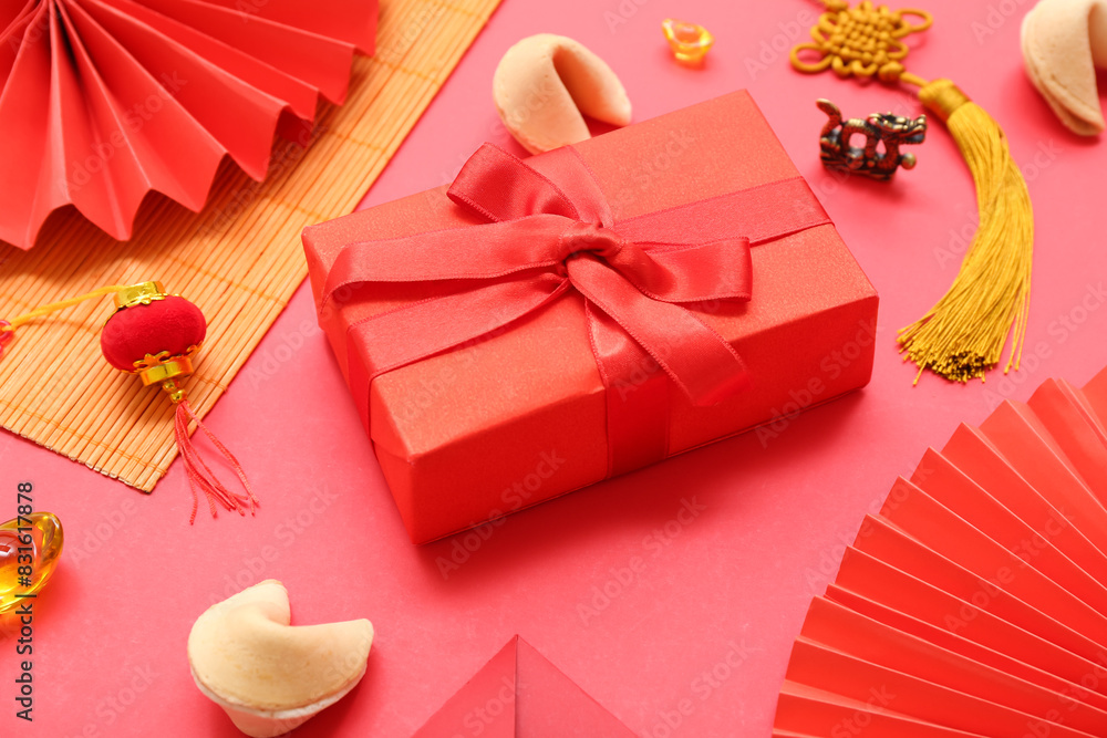 Gift box with fortune cookies and Chinese symbols on red background. New Year celebration
