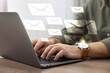 © New Africa - Man typing on laptop at table indoors, closeup. Many illustrations of envelope as incoming messages over device