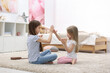 © New Africa - Cute little sisters playing clapping game with hands at home