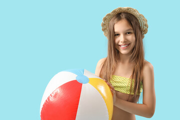 Poster - Cute little girl in swimsuit and hat with beach ball on blue background