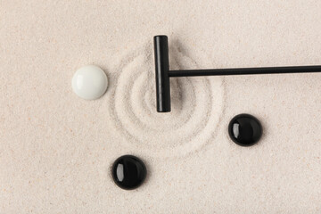 Wall Mural - Rake and stones on sand with lines in Japanese rock garden, top view. Zen concept