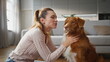© stockbusters - Cheerful girl stroking dog in apartment close up. Smiling woman caressing pet