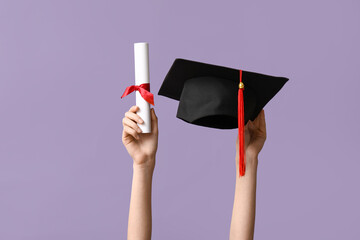 Wall Mural - Female hands with graduation hat and diploma on lilac background