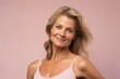 © Stocknterias - Portrait of a beautiful middle-aged woman on a pink background