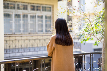 Wall Mural - Woman enjoy the city view outside the balcony