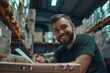 © Ahmed - Smiling warehouse manager at work, he is writing a document and checking orders: logistics and delivery service concept