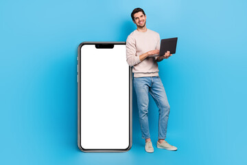 Aufkleber - Full size photo of intelligent man wear sweatshirt hold laptop stand near smartphone display empty space isolated on blue color background