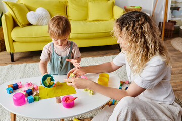 Wall Mural - A curly mother engages with her toddler daughter in Montessori play, exploring toys together in a warm home setting.