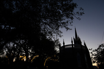 Wall Mural - Natchez, Mississippi, USA - April 21, 2024: Twilight silhouettes a tree and a historic church of downtown Natchez.