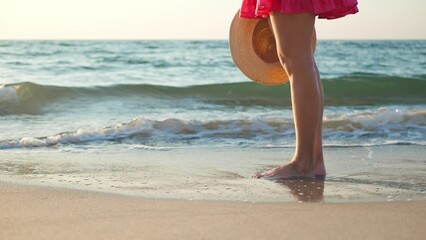 Wall Mural - Woman standing barefoot on beach in morning, closeup