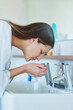 © Adene Sanchez/peopleimages.com - Sink, washing face and woman with water in bathroom for hygiene, cleaning and morning routine. Liquid, aqua and female person with skincare for cosmetics, dermatology and facial health at home