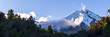 © robertharding - Panoramic view of Mount Taraniki, snowy volcano summit with a blue sky and forest in the evening, North Island, New Zealand, Pacific