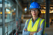 © standret - Confident female engineer at construction site wearing hard hat and vest