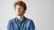 © Sajawal - portrait of a european red-haired student guy dressed in a blue denim shirt on a white studio background