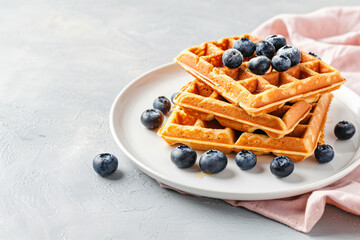 Wall Mural - a plate of waffles with blueberries on a pink napkin