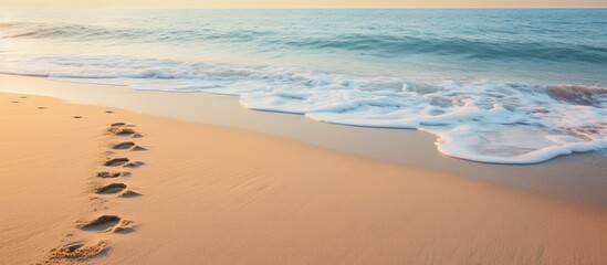 Wall Mural - Footprints in the sand with wave approaching. Creative banner. Copyspace image