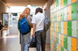 © Connect Images - Two students walk down a school hallway with colorful lockers on the right side.