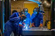 © Connect Images - Three people are wearing protective gear while performing welding tasks in an industrial setting.
