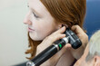 © Connect Images - Woman performing an ear examination with an otoscope