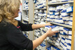 © Connect Images - Woman stocking pharmacy shelves with medication.