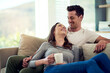 © Bester/peopleimages.com - Couple, drinking coffee and laugh in home living room, talking or bonding together to relax. Tea cup, happy man and woman in funny conversation on sofa for healthy relationship, connection or support