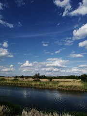 Sticker - Scenic view of a water canal flowing through a landscape with yellowing grass and trees