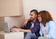 © peopleimages.com - New home, boxes and couple with laptop, smile and property with real estate, cardboard and goals. People, apartment and man with woman, internet or computer to pay mortgage, rent and bonding together