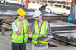 © JU.STOCKER - Engineer and female foreman team checking project at precast concrete factory site, Caucasian engineer and worker in hardhats discussing on construction site