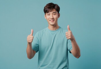 Canvas Print - A positive young man with a thumbs up gesture. Wearing a simple teal t-shirt, he showcases a friendly smile.