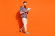 © deagreez - Full size photo of focused man with red long beard wear stylish shirt go with tablet to empty space isolated on orange color background