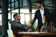 © Katleho Seisa/peopleimages.com - Business, men and shaking hands with collaboration in conference room for deal and partnership. Teamwork, woman and meeting in office for brainstorming, strategy and planning for project in New York