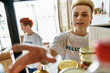 © Bliss - A young woman in a t-shirt in a kitchen setting, part of a lesbian couple volunteering together.