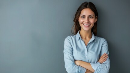 Happy young smiling confident professional business woman wearing blue shirt, pretty stylish female executive looking at camera, standing arms crossed isolated at gray background.