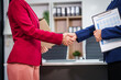 © NanSan - Two Asian businesswomen shake hands, collaborating on financial matters, discussing comments and suggestions regarding the stock market, loans, securities law, and investment strategies.