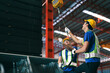 © Nunkung - Young caucasian industrial worker holds belt for lift heavy load on hoist of crane in steel factory.
