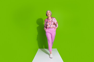 Sticker - Full length photo of charming attractive lady wear pink blouse walking road empty space isolated green color background