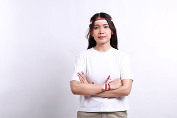 Portrait of a confident smiling Asian woman wearing white t-shirt, standing with arms folded and looking at the camera isolated over white background